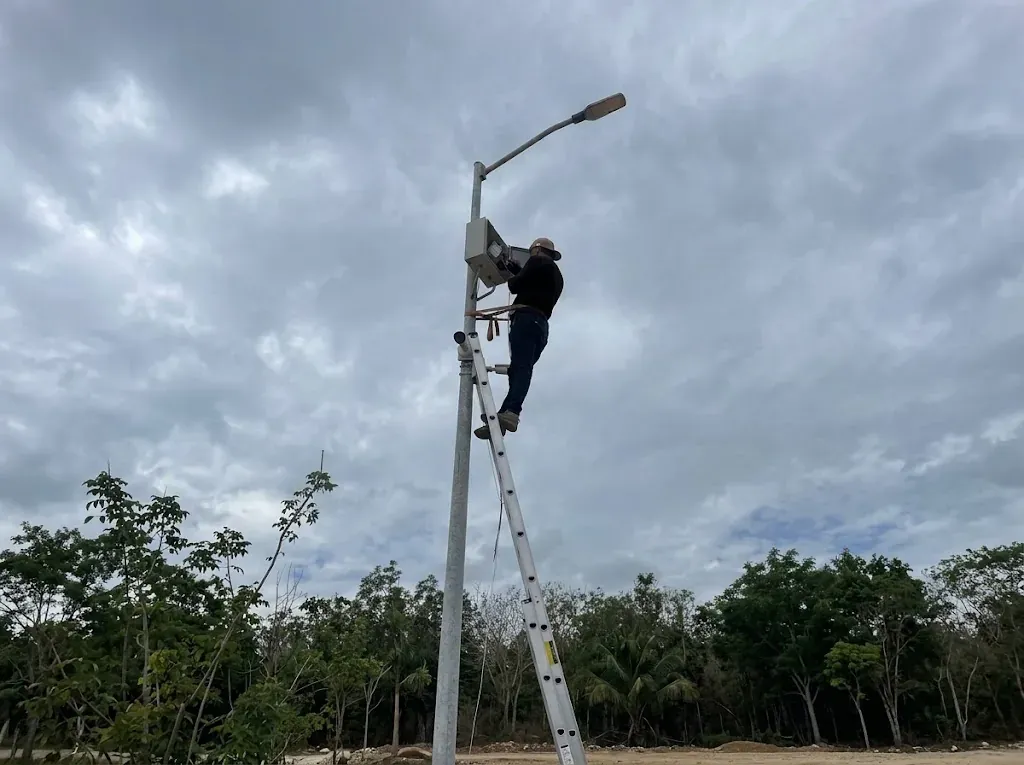 Técnico instalando cámara y gabinete en poste